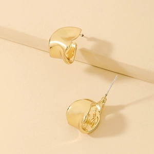 Detailed view of golden irregular geometric earrings with textured metallic finish