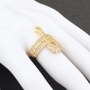 Macro detail of gold safety pin ring with micro-paved zircons on model hand