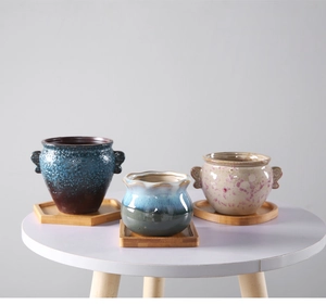 Ceramic succulent pots in various glazes set on geometric bamboo drainage trays