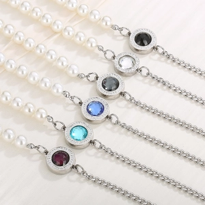 Detail of Cuban chain and pearl necklaces with crystal encrusted round gemstone pendants