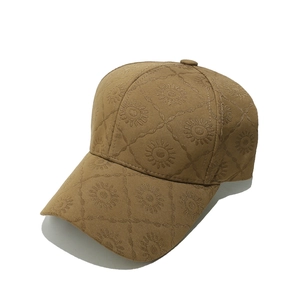 Détail de la casquette marron avec broderie de tournesols et texture de maille losange