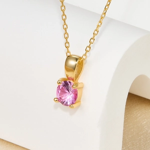 Detail of pink birthstone pendant in 4-prong setting on a gold O-chain necklace