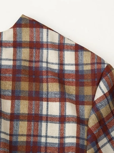 Detail of red and blue plaid woven fabric texture showing craftsmanship of the mini dress