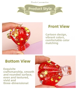 Detail of red hot air balloon keychain with liquid sand and gold star accents