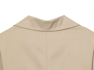 Vista detallada del cuello de vestido beige con textura de sarga y costuras de alta calidad