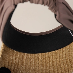 Detail of woven straw brim and black fabric trim on an open-top sun visor hat