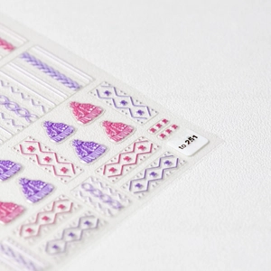Detail of 5D embossed nail stickers featuring pink and purple 3D knit sweater textures