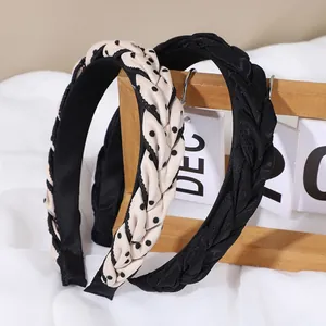 Détail des serre-têtes tressés à pois et noirs avec une doublure intérieure antidérapante