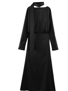Détail d'une robe mi-longue en satin noir élégante avec col foulard et coupe ajustée à la taille