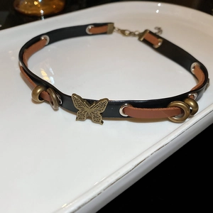 Detail of vintage leather choker with metal butterfly pendant and adjustable buckle closure