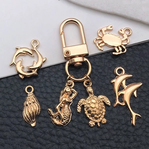 Detailed macro of gold alloy sea life pendants including mermaid and turtle charms