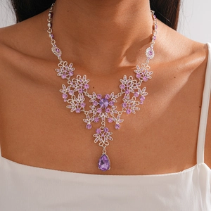 Detail of luxury flower necklace with purple crystals and water drop pendant on a model