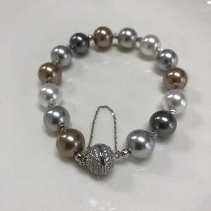Close-up of multi-color pearls with a sparkling crystal magnetic clasp and safety chain