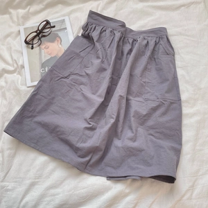 Detailed view of grey cotton kitchen apron featuring large side pockets and drawstring waist
