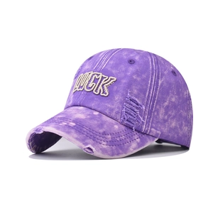 Detail shot of distressed purple denim cap with white LUCK 3D embroidery and frayed edges
