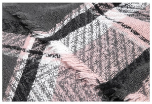 Macro-opname van roze en grijze plaid poncho-stof met zachte franjedetails