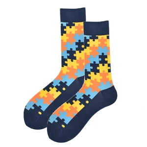 Detail view of colorful jigsaw puzzle pattern crew socks with blue heels and toes