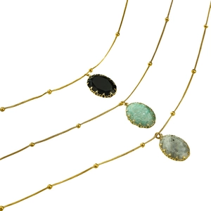 Vintage gold necklaces with oval natural stone pendants in black, green, and grey colors