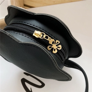 Close-up of cat-shaped mini bag with PU leather texture and gold flower zipper puller