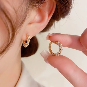 Elegant C-shaped twisted gold hoop earrings with small baroque pearls for women