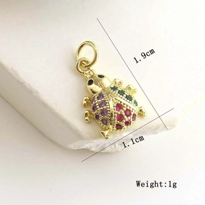 Detailed macro view of gold ladybug charm with multi-colored crystals and dimensions