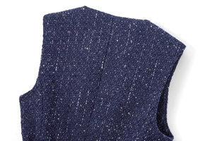 Close-up of deep blue sequined tweed fabric texture and shoulder detail on vest
