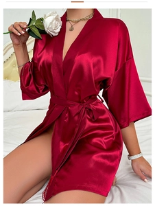 Detailed close-up of dark red satin robe fabric with silky texture and wrap belt