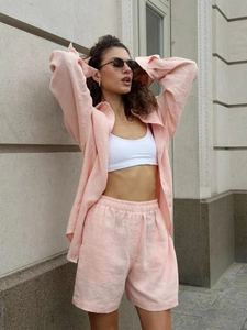 Detail of pink cotton linen long sleeve shirt and shorts set on a model outdoors