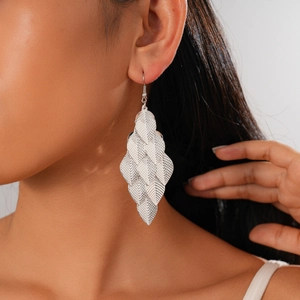 Close-up of silver layered leaf earrings with metallic texture on female model