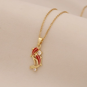 Close-up of golden necklace featuring red koi fish pendant with cubic zirconia stones