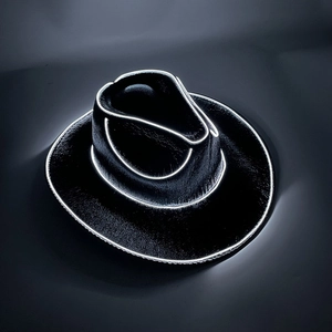 Detail of LED light-up cowboy hat featuring white neon glowing edges on black fabric