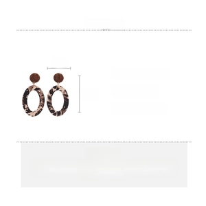 Macro view of leopard print oval fabric earrings with detailed size and material specs