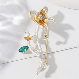 Elegant lotus brooch with enamel petals and green rhinestone inlay on a white background