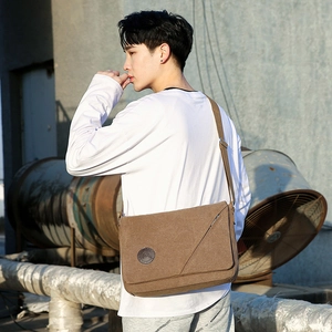Brown canvas messenger bag for men featuring adjustable shoulder strap and casual style