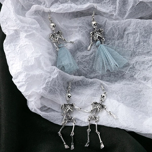 Detail of silver skeleton earrings with blue tulle skirt on a gothic textured background