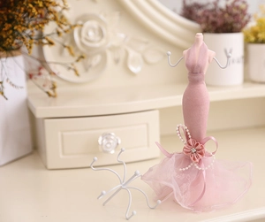 Detailed view of pink mannequin jewelry stand with lace dress and pearl decorations