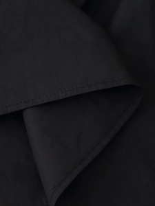 Detailed macro view of black fabric texture and double-stitched seam on vacation dress