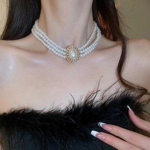 Macro view of a French vintage three-layer pearl choker with a rhinestone pendant
