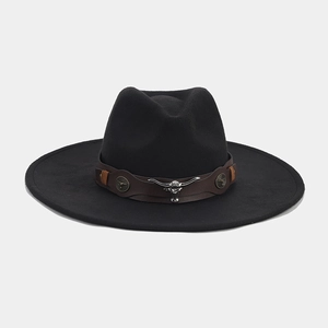 Detail of western fedora hat featuring a vintage bull head buckle and brown leather band
