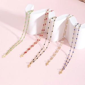 Detail of colorful beads and gold plated cross pendants on minimalist necklaces