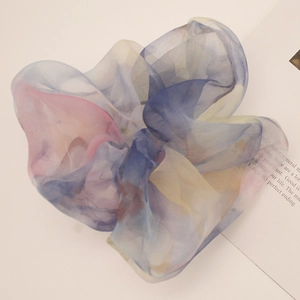 Macro detail of large gradient organza scrunchie with soft pastel blue and pink tones