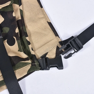 Detail of cargo vest showing camouflage fabric with black plastic buckle and nylon strap