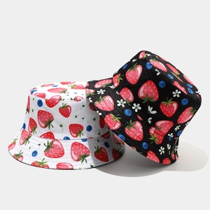 Detailed view of reversible cotton bucket hats featuring vibrant strawberry and blueberry prints