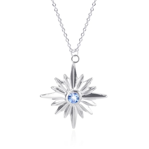 Macro shot of a silver star pendant featuring a centered blue gem on a fine chain