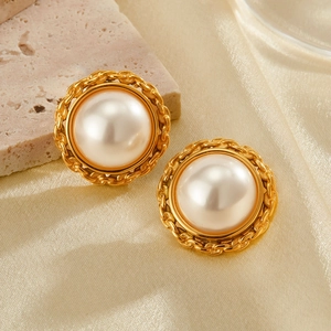 Vintage gold plated stainless steel pearl stud earrings on a luxury silk background