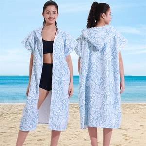 Blue and white paisley microfiber hooded beach poncho towel for adults on a sunny beach