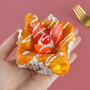 Realistic PU strawberry danish pastry model held by hand with a pink background