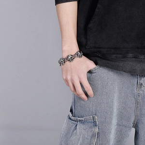 Detailed view of silver skull bracelet in gothic style worn by a male on wrist