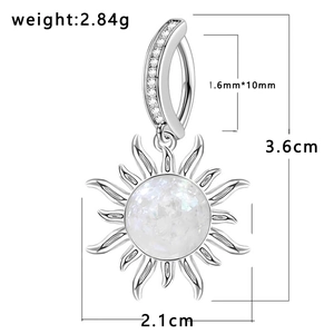 Detail of silver sun belly button ring with opal center and zircon stones measuring 3.6x2.1cm