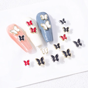 Détail des breloques à ongles en forme de papillon 3D émaillé en rouge, noir et blanc